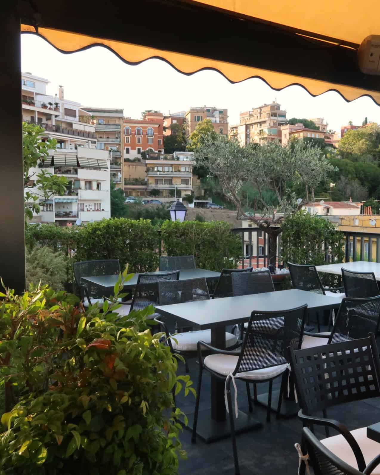 Table and chairs with views of Rome at the rooftop of Trilussa Palace Hotel